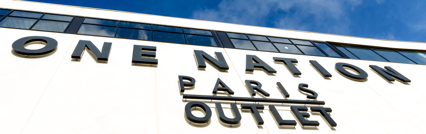 One Nation París, nombrado mejor centro comercial outlet de Francia por un organismo europeo independiente. Foto del cartel del centro